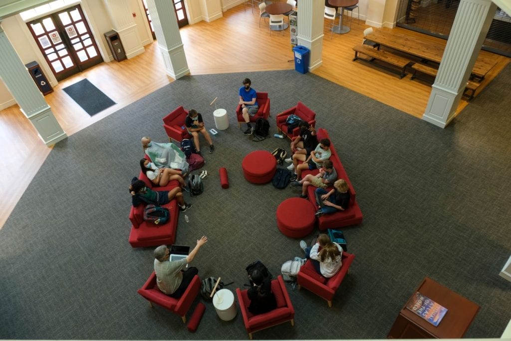 Students meet with a faculty member in the library